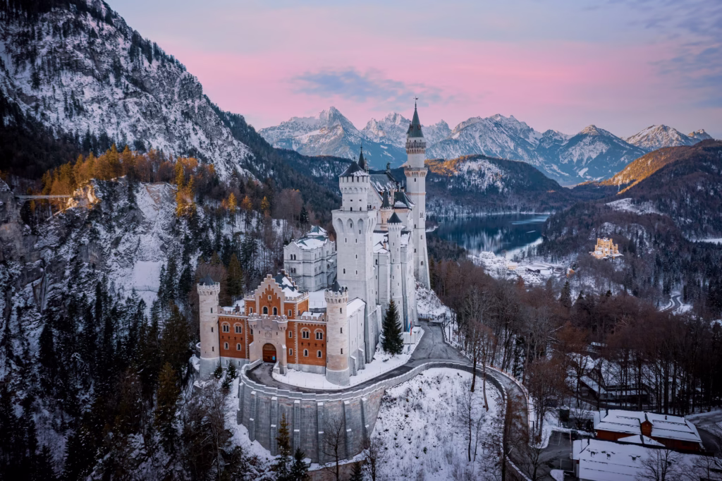 Scenic shot of the Neuschwanstein Castle in Germany surrounded by snowy mountain forests